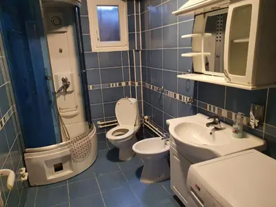 a blue tiled bathroom with a toilet and a sink at Smestaj Boki in Soko Banja