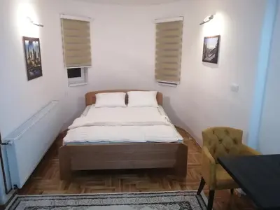 a small bedroom with a bed and a chair at ORTODOKS in Brus