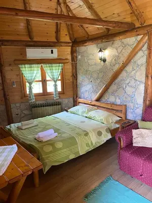 a bedroom with a bed and a couch in a cabin at Smestaj Milovanovic in Soko Banja
