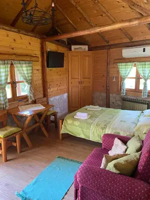 a bedroom with a bed and a table and a couch at Smestaj Milovanovic in Soko Banja