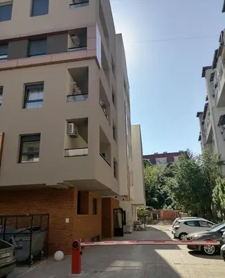 an apartment building with a parking lot in front of it at APARTMAN ANA in Niš