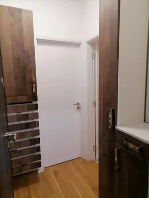 a white door in a room with a wooden floor at APARTMAN ANA in Niš