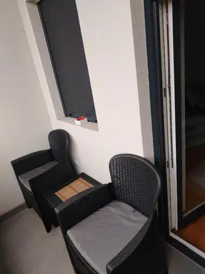 two chairs and a table in a room with a window at APARTMAN ANA in Niš