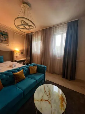 a living room with a blue couch and a table at Dis Delux in Kruševac