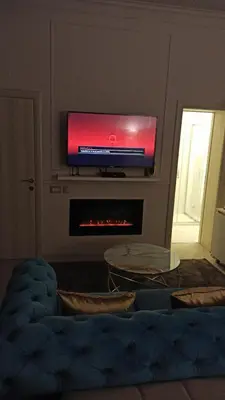 a living room with a flat screen tv above a fireplace at Dis Delux in Kruševac