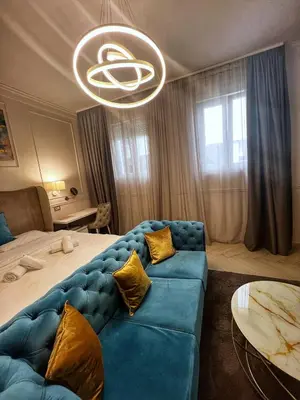 a living room with a blue couch and a bed at Dis Delux in Kruševac