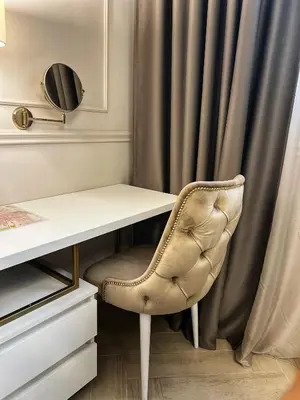 a desk and a chair in front of a curtain at Dis Delux in Kruševac