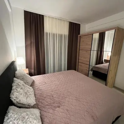 a bedroom with a large bed and a mirror at Milmari Apartman Haski N55 in Kopaonik