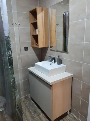 a bathroom with a white sink and a mirror at Milmari Apartman Haski N55 in Kopaonik