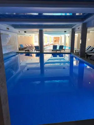 a swimming pool in a building with chairs in it at Milmari Apartman Haski N55 in Kopaonik