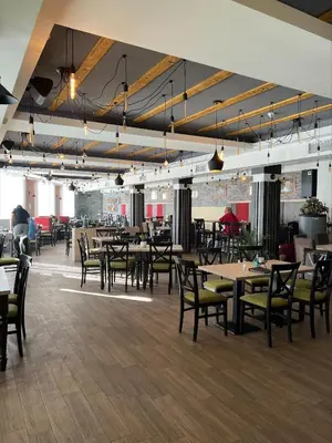 a dining room with tables and chairs in a building at Milmari Apartman Haski N55 in Kopaonik