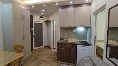 a kitchen with white cabinets and a counter top at Vila Plan Karaman greben in Raška