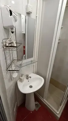 a bathroom with a white sink and a shower at Vila Plan Karaman greben in Raška