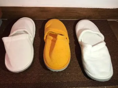 a pair of white shoes with yellow sole on a floor at Studio-Apartman Dream018 in Brzeće