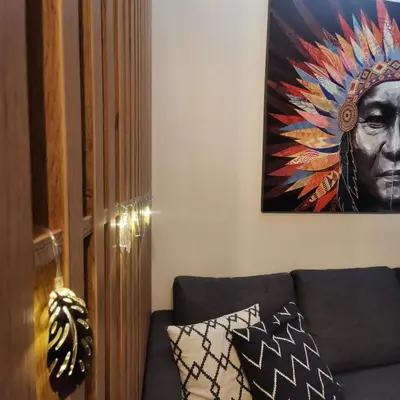 a living room with a couch and a painting on the wall at Kai Apartman in Kopaonik