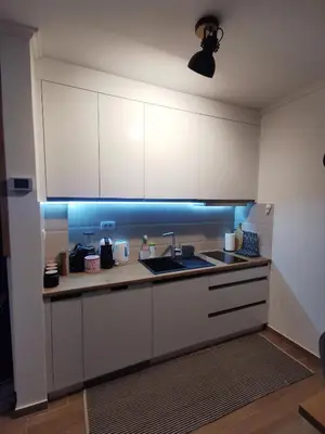 a kitchen with white cabinets and a sink at Kai Apartman in Kopaonik