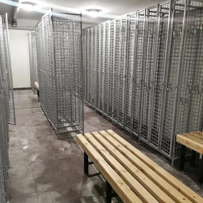 a room with a wooden bench and a wall of cells at Kai Apartman in Kopaonik
