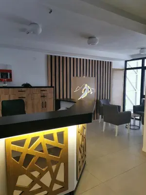 a kitchen with a counter and chairs in a room at Kai Apartman in Kopaonik