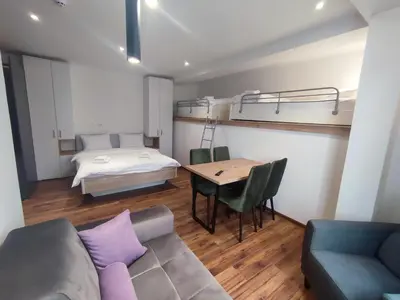 a living room with a couch and a bed and a table at Apartmani Sorak Kopaonik, Studio Apartman A10 in Kopaonik