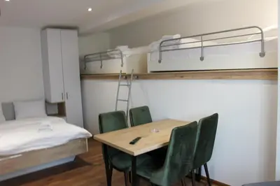a room with a table and chairs and bunk beds at Apartmani Sorak Kopaonik, Studio Apartman A10 in Kopaonik