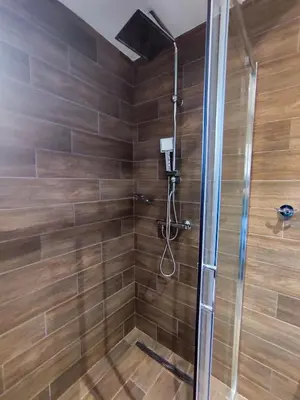a bathroom with a shower with wooden tiles at Apartmani Sorak Kopaonik, Studio Apartman A10 in Kopaonik
