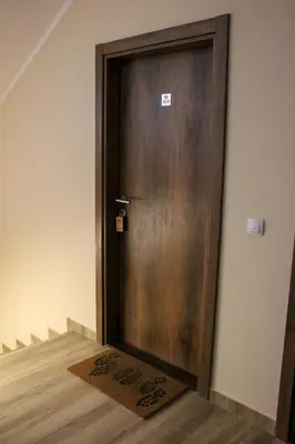 a wooden door with a mat in front of it at Apartmani Sorak Kopaonik, Studio Apartman A10 in Kopaonik
