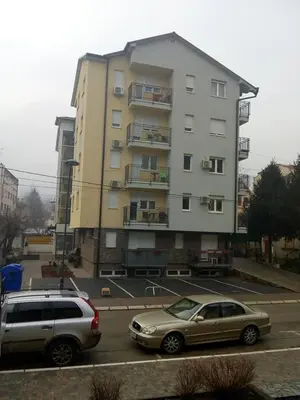 two cars parked in a parking lot in front of a building at Apartman Mihajlovic in Soko Banja
