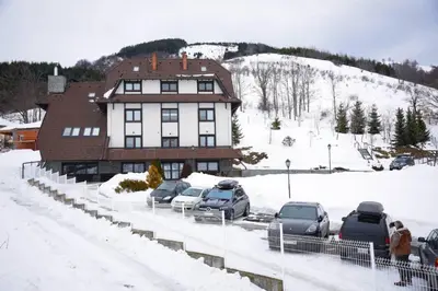 a group of cars parked in front of a building in the snow at Villa Mramor in Brzeće
