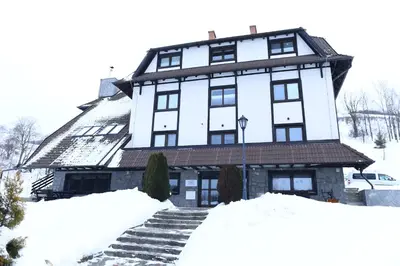 a large white building with snow on the steps at Villa Mramor in Brzeće