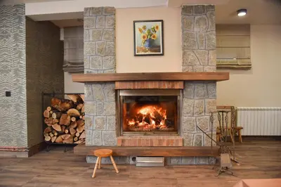 a living room with a stone fireplace at Villa Mramor in Brzeće
