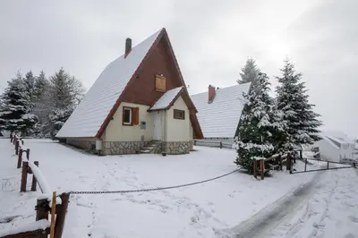 a barn with snow on the ground in front of it at Villa Teodora in Kopaonik