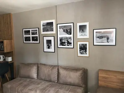 a living room with a couch and pictures on a wall at Apartmani A in Kopaonik