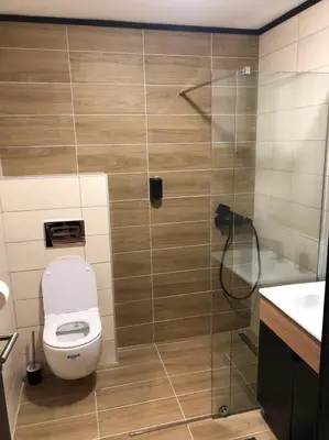 a bathroom with a toilet and a glass shower at Apartmani A in Kopaonik