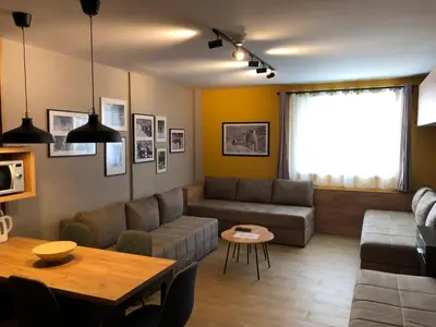 a living room with a couch and a table at Apartmani A in Kopaonik