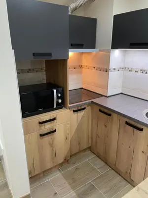 a kitchen with wooden cabinets and a microwave at DREAM house in Paraćin