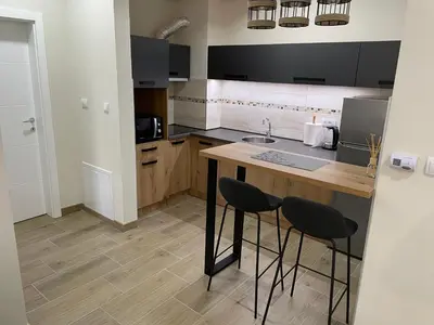a kitchen with a counter and two stools in it at DREAM house in Paraćin