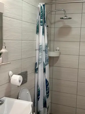 a bathroom with a shower curtain and a toilet at Lilyy in Leskovac