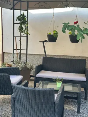a patio with chairs and tables and potted plants at Lilyy in Leskovac
