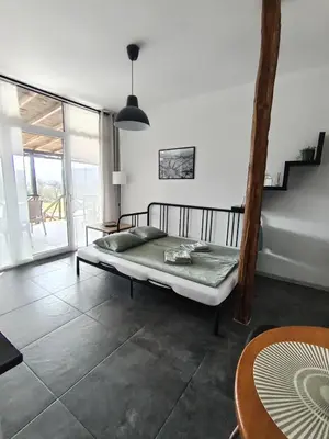 a bedroom with a bed and a table and a window at My Place Apartmani in Krivi Vir