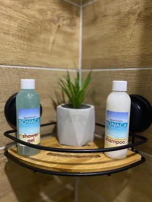two bottles of water and a plant on a shelf at Apartman Bonaca in Niš