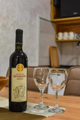 a bottle of wine and two wine glasses on a table at STIV Apartmani in Lukovo
