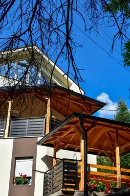 a house with a wooden pergola in front of it at STIV Apartmani in Lukovo