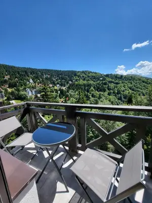 a table and chairs on a balcony with a view at Apartman Mela Kop 11 in Kopaonik