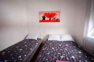 a bedroom with two beds and a painting on the wall at Apartman Pašajlić in Vrnjačka Banja