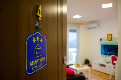a door with a sign on it in a room at Apartman Pašajlić in Vrnjačka Banja