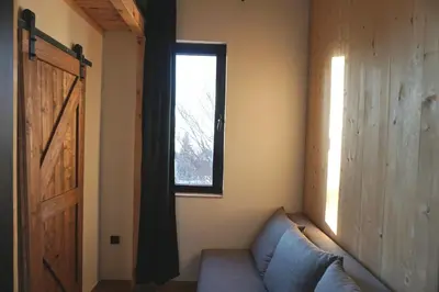 a living room with a blue couch and a window at Montana in Kopaonik