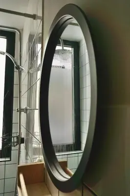 a round mirror in a bathroom with a shower at Montana in Kopaonik