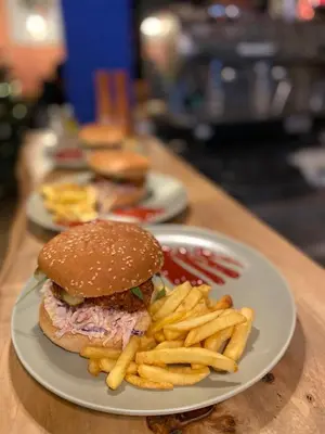 a plate with a sandwich and french fries on a table at Montana in Kopaonik