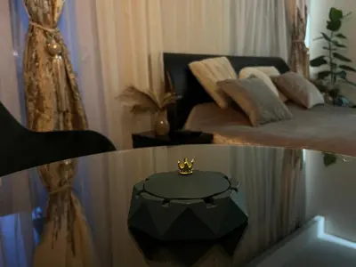 a room with a bed and a table with a crown on it at STUDIO DJORDJO in Kruševac