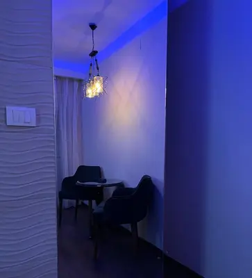 a dining room with two chairs and a table with a chandelier at STUDIO DJORDJO in Kruševac